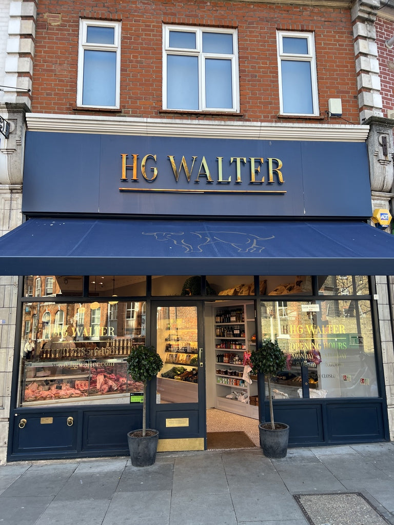 Storefront of HG Walter with a blue awning and glass windows.