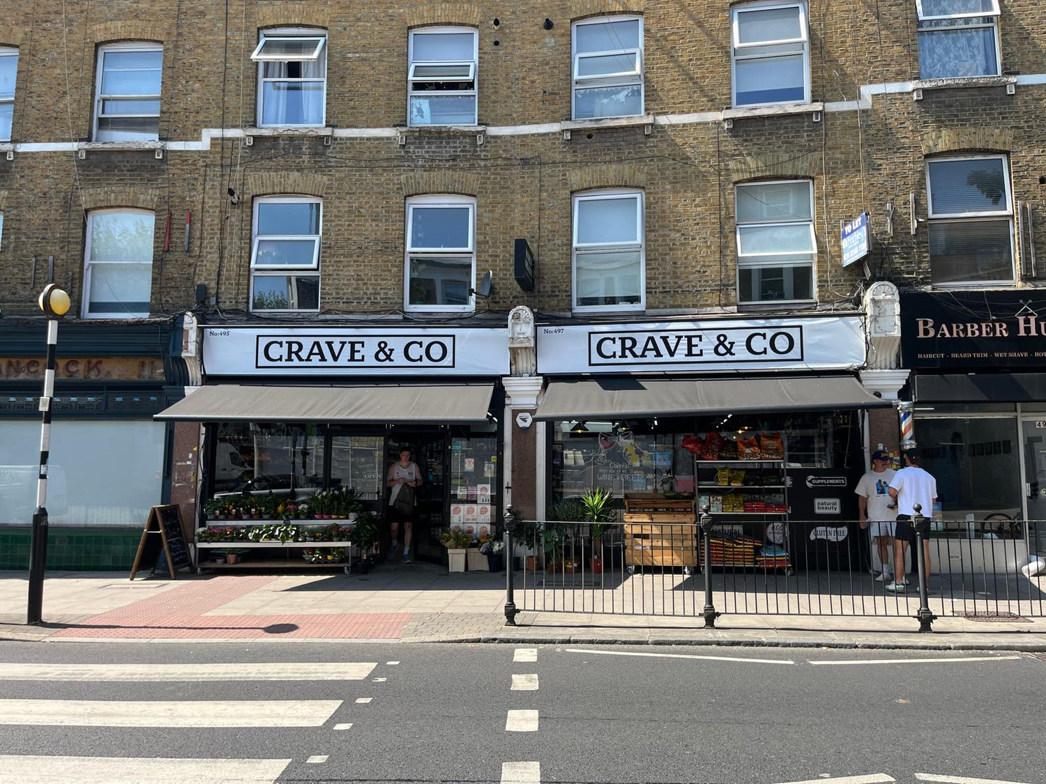 Storefront of Crave & Co with people walking by.